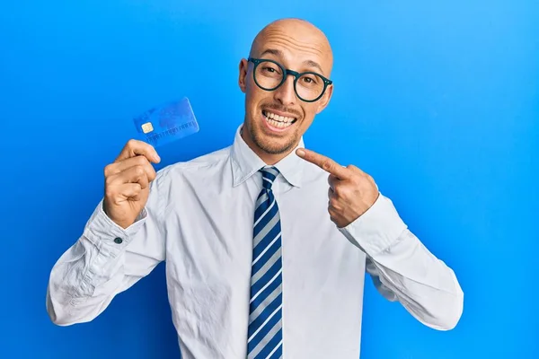 Skallig Man Med Skägg Håller Kreditkort Ler Glad Pekar Med — Stockfoto