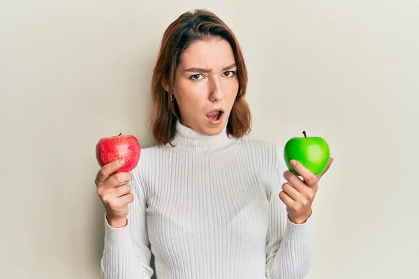 Νεαρή Καυκάσια Γυναίκα Κρατώντας Κόκκινο Και Πράσινο Μήλο Στο Πρόσωπο — Φωτογραφία Αρχείου
