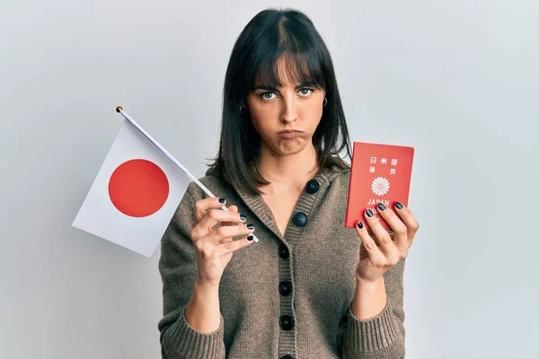 Fiatal Spanyol Kezében Japán Zászló Útlevél Szkeptikus Ideges Homlokráncolás Ideges — Stock Fotó