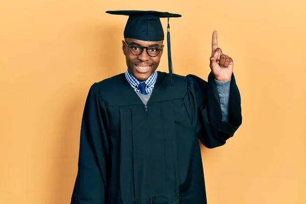 Молодий Афроамериканець Випускному Капюшоні Обрядовому Одязі Показує Пальцем Номер Один — стокове фото