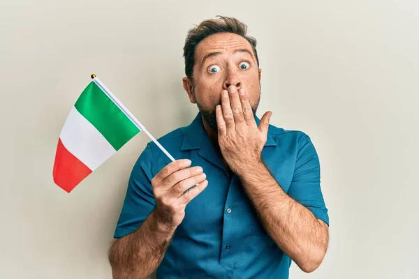 Мужчина Средних Лет Держит Итальянский Флаг Прикрывающий Рот Рукой Шокирован — стоковое фото
