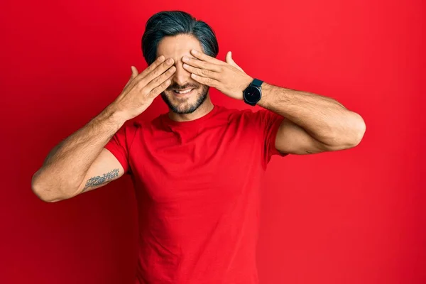 Young Hispanic Man Wearing Casual Red Shirt Covering Eyes Hands — Photo