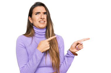 Gündelik kıyafetler giyen genç İspanyol kadın iki eliyle endişeli ve endişeli bir ifadeye işaret ediyor. 