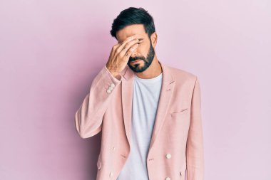 İş ceketi giyen genç İspanyol adam yorgun burnu ve gözleri ovuşturup yorgun ve baş ağrısı çekiyor. Stres ve hüsran kavramı. 