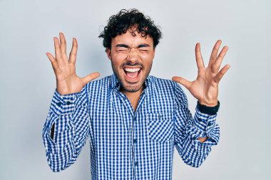 Gündelik kıyafetler giyen genç İspanyol adam başarı için deli ve çılgınlığı kutluyor kollarını kaldırmış ve gözlerini kapatmış heyecanla bağırıyor. Kazanan konsept 