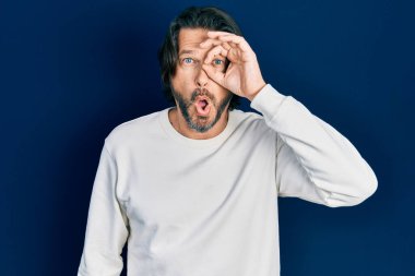 Orta yaşlı, sıradan kıyafetler giyen, şaşırmış yüz ifadesiyle şaşırmış, parmaklarından bakan beyaz bir adam. İnançsız ifade. 