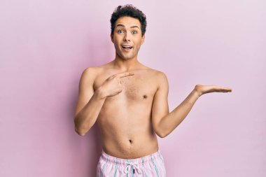 Mayo giyen genç yakışıklı adam hayrete düşmüş ve kameraya gülümsüyor.. 