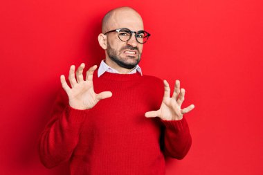 Sıradan kıyafetler ve gözlük takan genç kel adam korku ifadesinden korkmuş ve dehşete düşmüş. El hareketlerini durdur, şok içinde bağır. panik konsepti. 