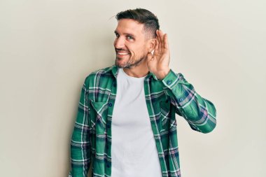 Sakallı, sıradan kıyafetler giyen, ağzı kulaklarına varan gülümseyerek dedikoduları ve dedikoduları dinleyen yakışıklı bir adam. Sağırlık kavramı. 