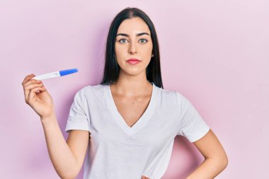 Mavi gözlü güzel bir kadının hamilelik testi sonucu davranışları ve kendine güveni var. 