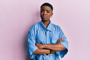 Kollarını kavuşturmuş, habersiz ve kafası karışmış genç Afrikalı Amerikalı kadın. şüphe kavramı. 