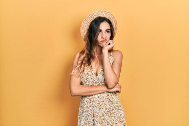 Yaz şapkası takan genç İspanyol kız çapraz kollu depresyondan sıkılmış ve yorgun görünüyor.. 