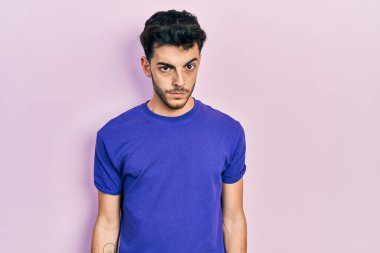 Gündelik tişört giyen, kuşkucu ve gergin genç İspanyol adam sorun yüzünden üzgün. negatif kişi. 