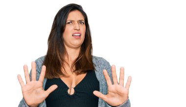 Güzel İspanyol kadın gündelik kıyafetler giyiyor. Korkudan dehşete düşmüş ve korkmuş. El hareketlerini durdur, şok içinde bağır. panik konsepti. 