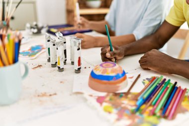 Resim stüdyosundaki masada oturan Afrikalı Amerikalı sanatçı çift..