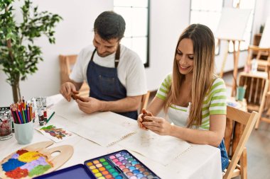 İki İspanyol öğrenci gülümsüyor sanat okulunda kilden heykeller yapıyorlar..