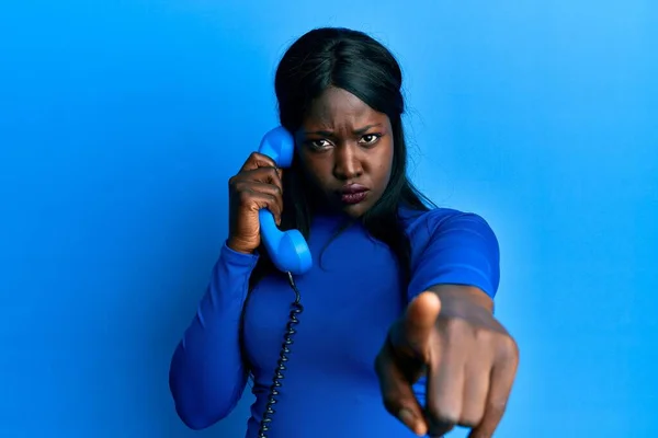 Afrykańska Młoda Kobieta Mówi Przez Telefon Vintage Wskazując Palcem Aparat — Zdjęcie stockowe