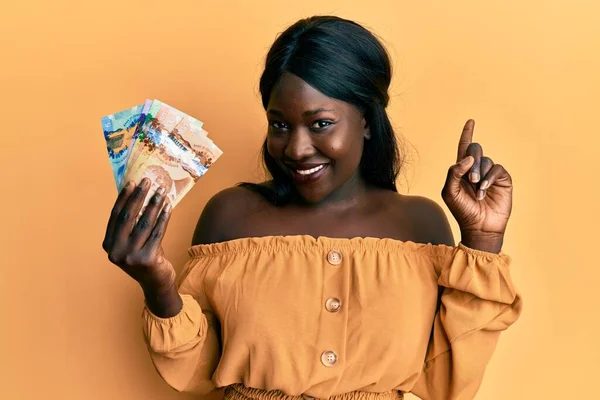 Αφρικανή Νεαρή Γυναίκα Που Κρατάει Καναδέζικα Δολάρια Χαμογελώντας Μια Ιδέα — Φωτογραφία Αρχείου