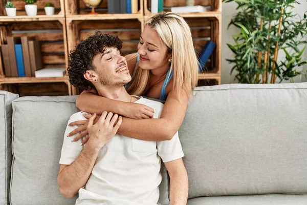 Jovem Casal Sentado Sofá Abraçando Casa — Fotografia de Stock