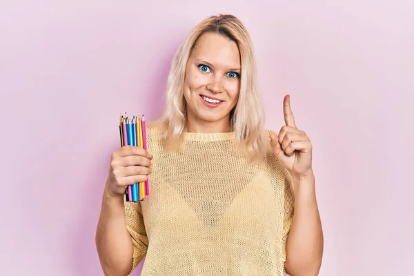 Beautiful Caucasian Blonde Woman Holding Colored Pencils Smiling Idea Question — ストック写真