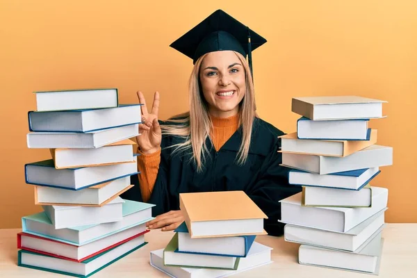 Ung Kaukasisk Kvinna Som Bär Examensdräkt Sitter Bordet Och Ler — Stockfoto