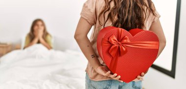 Genç bir kadın yatak odasında sevgilisine sevgililer günü hediyesiyle sürpriz yapıyor..