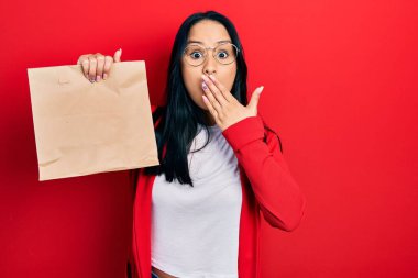 Burnuna piercing takan güzel İspanyol bir kadın. Ağzını ağızla kapatmış, şok olmuş ve hata yapmaktan korkan bir kadın. şaşırmış ifade 