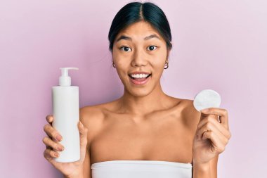 Genç Çinli kadın duş havlusu kullanıyor. Temiz losyon kullanıyor. Çılgınlığı kutluyor.. 