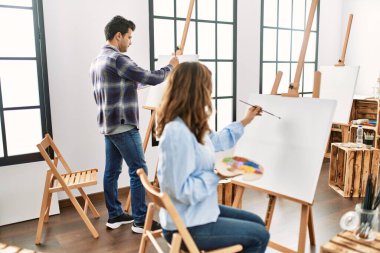 Sanat okulunda resim yaparken gülümseyen iki İspanyol öğrenci..