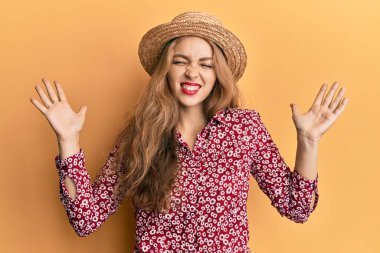 Sarışın, beyaz, yaz şapkası takan güzel bir kadın başarının çılgınlığını kutluyor. Kollarını kaldırmış, gözlerini kapatmış heyecanlı çığlıklar atıyor. Kazanan konsept 