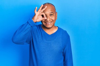 Orta yaşlı, sıradan giyinen, gülümseyen, mutlu, el pençe divan duran, el pençe divan duran Latin bir adam. 