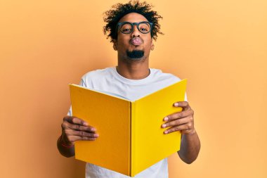 Sakallı, kitap okuyan, gözlüklü, kameraya bakıp öpüşen, güzel ve seksi bir Afrikalı Amerikalı. aşk ifadesi. 