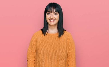 Yüzünde mutlu ve havalı bir gülümseme olan gündelik kıyafetler giyen genç İspanyol kadın. şanslı kişi. 