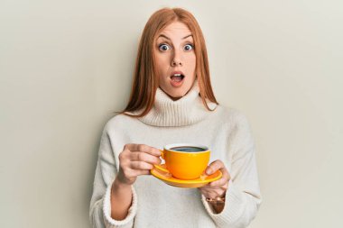 Bir fincan kahve içen genç İrlandalı kadın şaşkınlık ve şaşkınlık dolu bir ifade, korku ve heyecanlı bir yüz ifadesiyle şoka girdi.. 