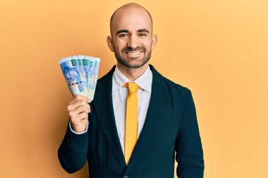 Güney Afrika 'da elinde 100 rand banknot tutan genç bir İspanyol işadamı. Olumlu ve mutlu görünüyor. Kendine güvenen bir gülümsemeyle dişlerini gösteriyor. 