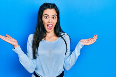 Gündelik kıyafetler giyen genç İspanyol kız zaferi mutlu bir gülümsemeyle ve kazanan yüz ifadesiyle kutluyor. 