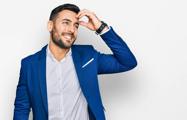 Young hispanic man wearing business jacket smiling confident touching hair with hand up gesture, posing attractive and fashionable 