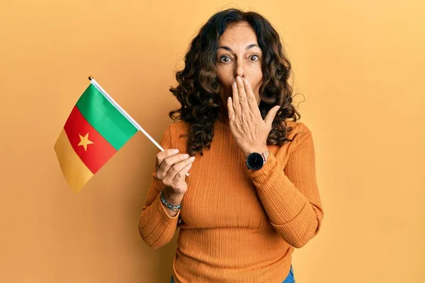 Hispánka Středního Věku Držící Kamerunskou Vlajku Ústech Šokovaná Vystrašená Omylu — Stock fotografie