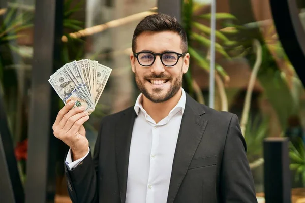 Joven Empresario Hispano Sonriendo Feliz Sosteniendo Dólares Americanos Ciudad —  Fotos de Stock