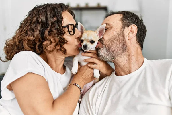 Casal Hispânico Meia Idade Sorrindo Feliz Sentado Sofá Beijando Cão — Fotografia de Stock