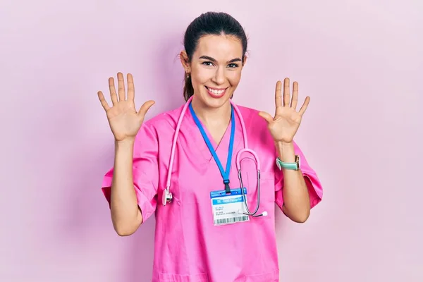 Doktor Üniforması Giyen Genç Esmer Kadın Steteskop Numarayı Gösterip Gösterirken — Stok fotoğraf