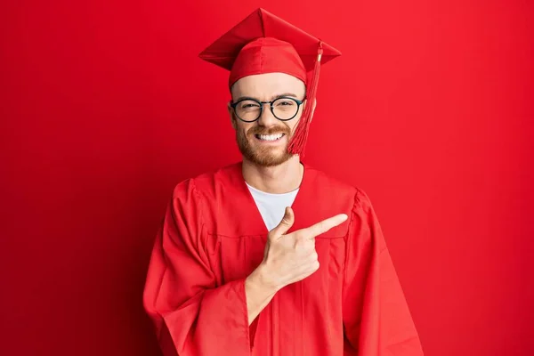 Νεαρός Κοκκινομάλλης Κόκκινο Καπέλο Αποφοίτησης Και Επίσημη Ρόμπα Χαρούμενος Χαμόγελο — Φωτογραφία Αρχείου