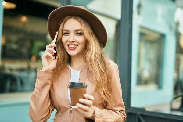 Junges Blondes Mädchen Spricht Auf Dem Smartphone Und Trinkt Kaffee — Stockfoto