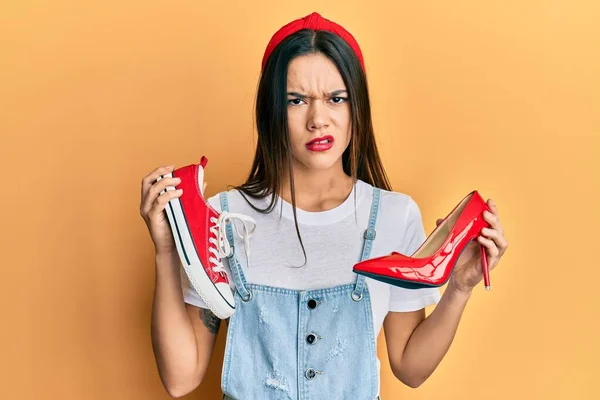 Ung Latinamerikansk Flicka Väljer Högklackade Skor Och Sneakers Skeptisk Och — Stockfoto