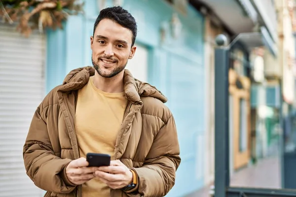若いヒスパニック系の男は 市内でスマートフォンを使用して幸せな笑顔 — ストック写真