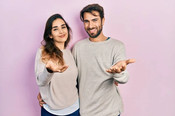Unga Latinamerikanska Par Bär Avslappnade Kläder Leende Glad Erbjuda Handflatan — Stockfoto