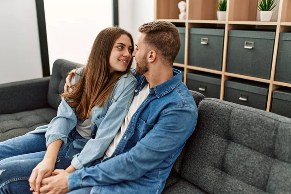 Young Caucasian Couple Sitting Sofa Hugging Home — Stock Photo, Image