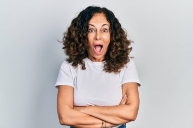 Orta yaşlı, kollarını kavuşturmuş, çılgın ve başarıyı kutlayan İspanyol bir kadın. Gözleri açık, heyecanlı bir şekilde çığlık atıyor.. 