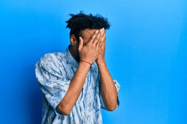 Sakallı, sıradan kıyafetler giyen, suratını ellerle örten ve ağlayan Afro-Amerikan genç bir adam. depresyon kavramı. 