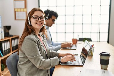 Ofiste çalışırken gülümseyen iki çağrı merkezi ajanı..